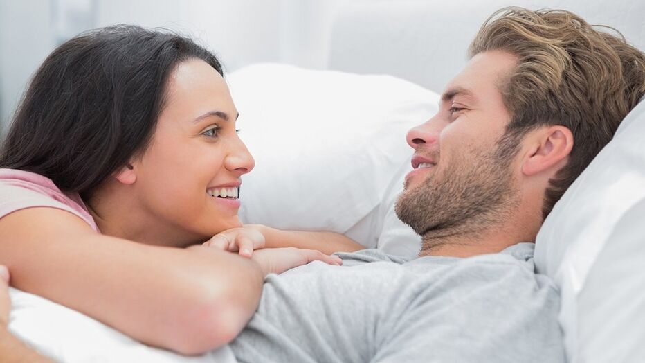 Happy women with men in bed
